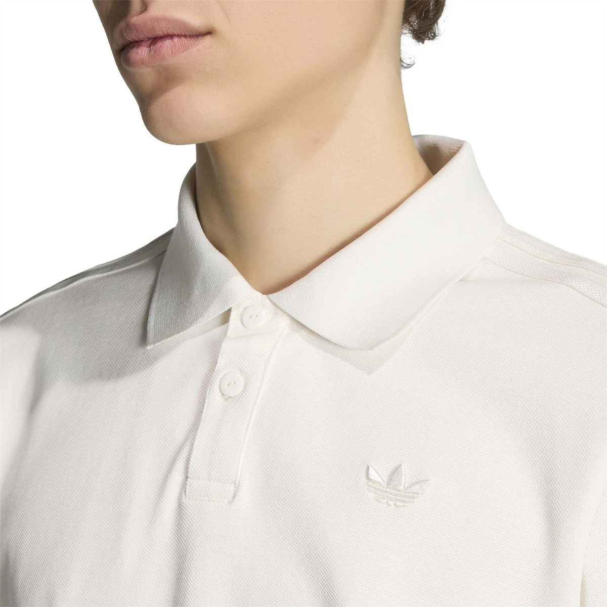 Cloud white polo shirt close-up of collared placket with button and adidas trefoil