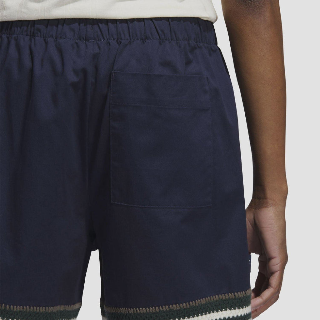 Indigo knit shorts with elastic waist, front pocket, and striped hem band