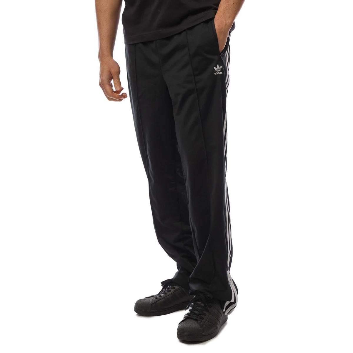 Black adidas Originals track pants with white side stripes and elastic cuffs