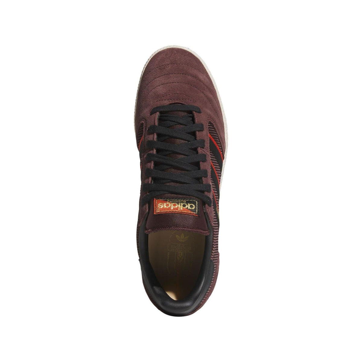 Front view of brown skate trainers with black laces, perforated toe cap, and red logo detail