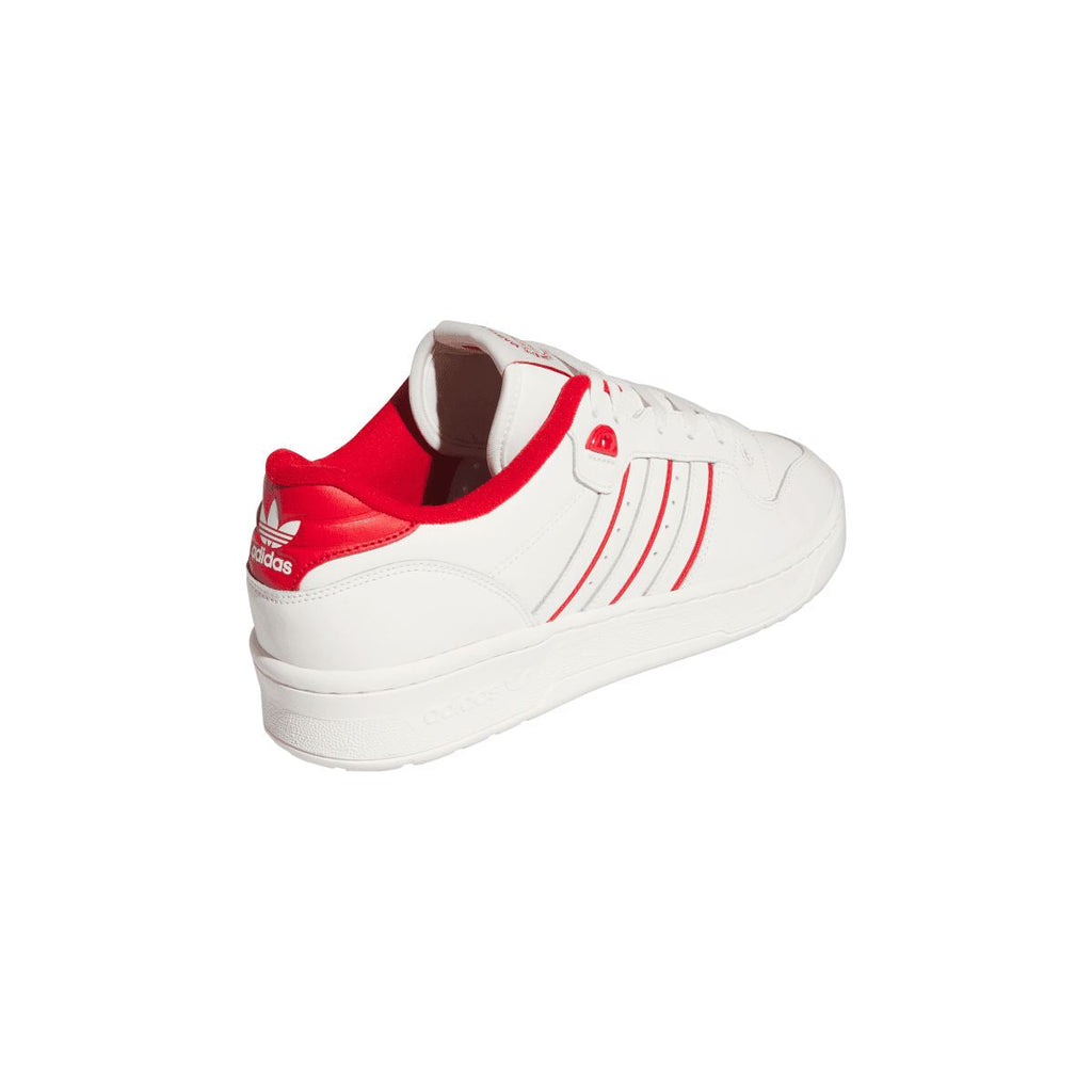 White lace-up trainer with red collar lining and side stripes on the heel.