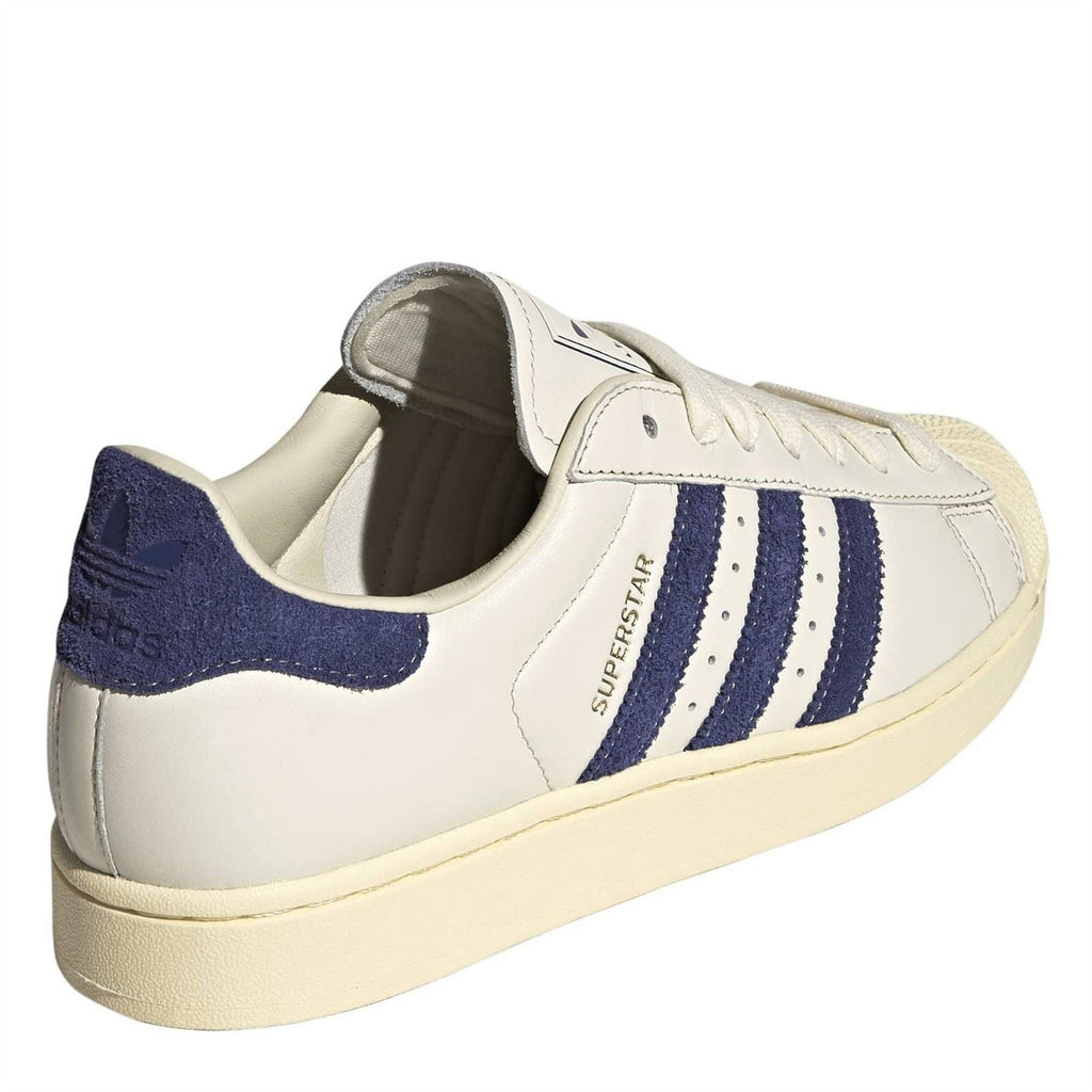 White adidas Originals Superstar II sneakers with navy heel panel, blue center stripes, lace-up