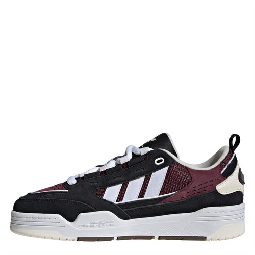 Kids' low-top trainers, side view, black with burgundy panels and white stripes