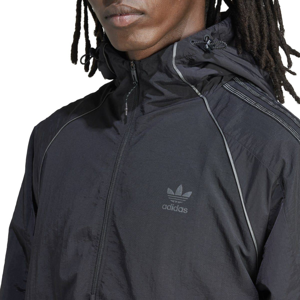 Close-up of black adidas anorak hood and front zipper with trefoil chest logo