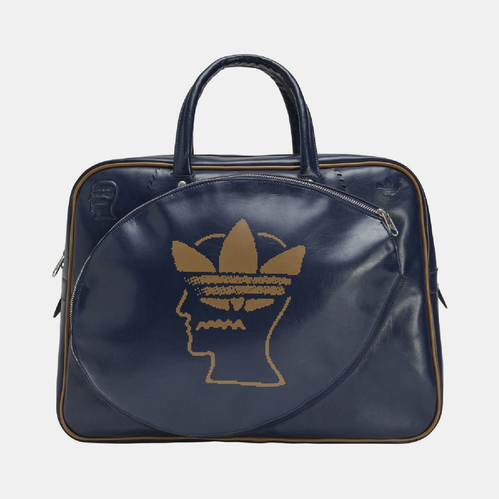 Navy duffel bag with top handles, side zips, and gold Trefoil head logo on front.