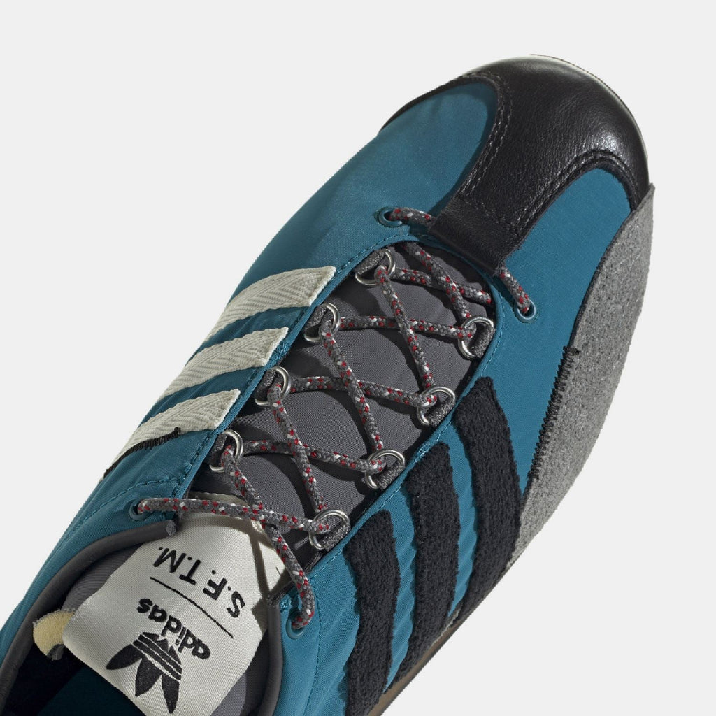 Teal adidas Country OG trainer close-up showing lace eyelets and three blue stripes