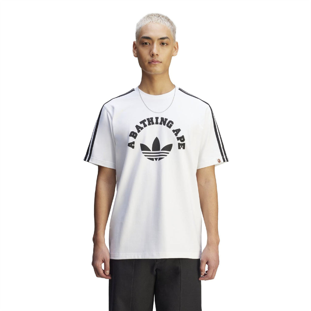 White T-shirt on model with A BATHING APE front graphic and black sleeve stripes