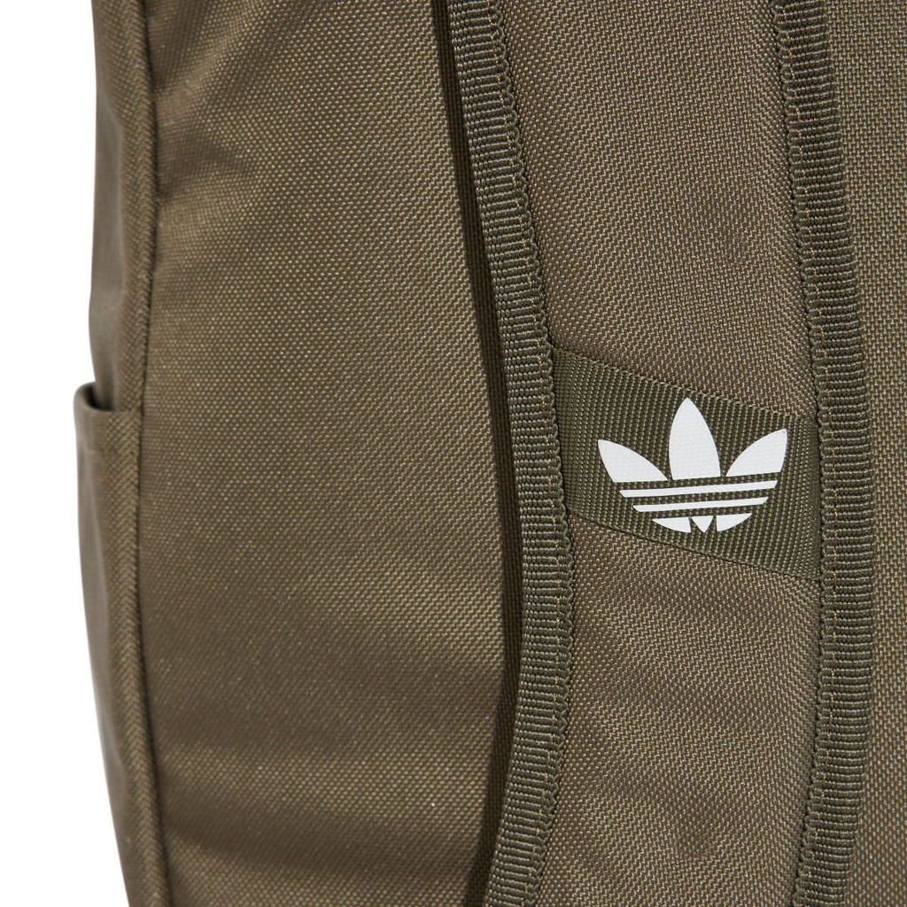 Olive backpack front panel close-up with white adidas trefoil logo and stitched seams