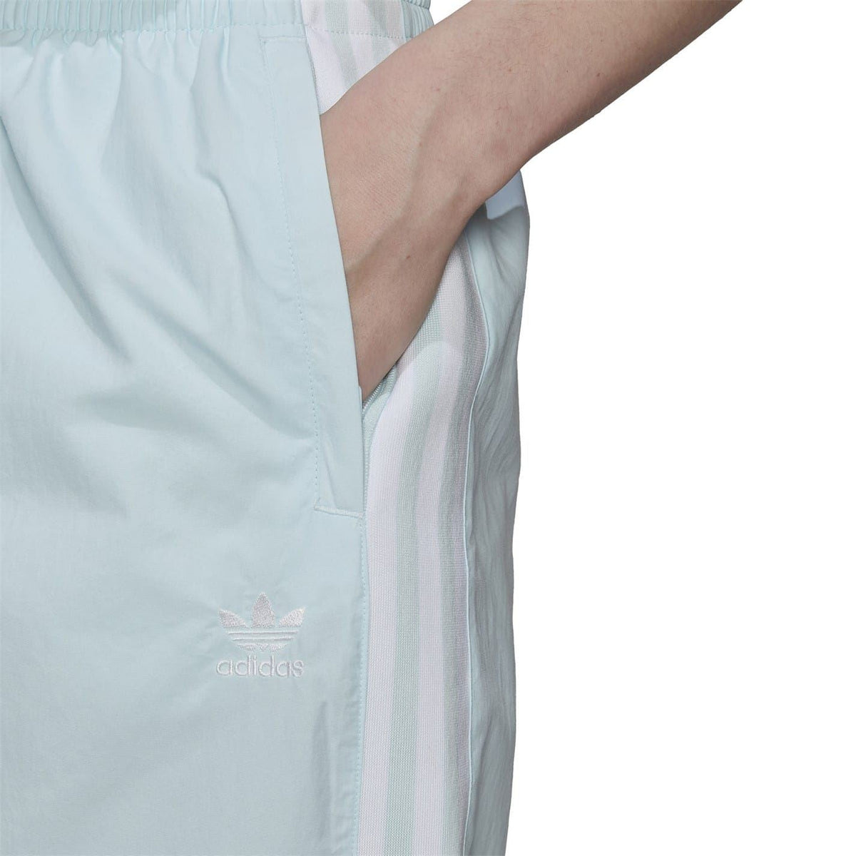 Light blue adidas logo on side of track sweatpants with vertical stripe panel