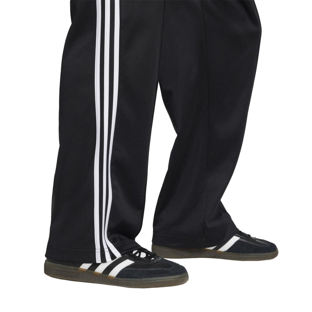 Black track pants with white side stripe trim and elastic cuff hem