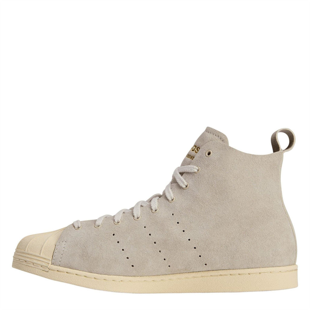 Cream suede high-top sneakers with lace-up and perforated panels, cream rubber sole.