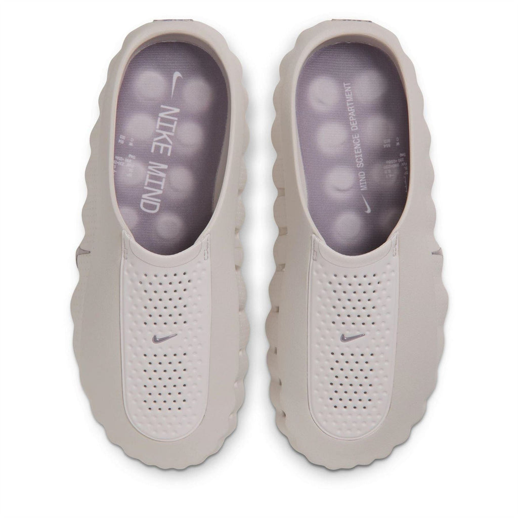 Pale white Nike slide sandals with perforated upper and Nike logo on insole