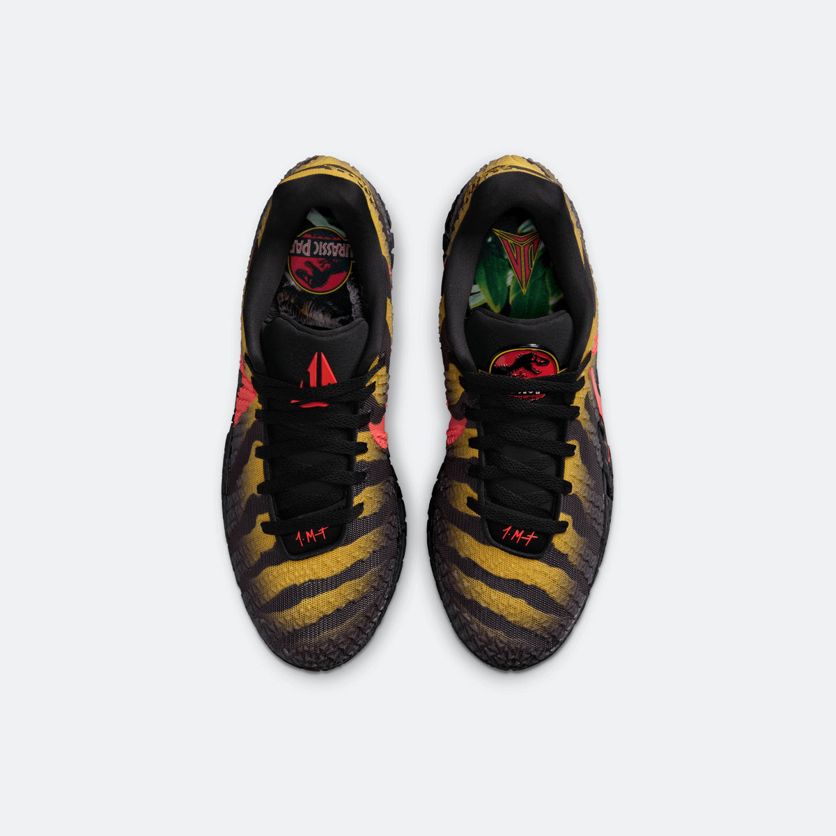 Front view of black lace-up sneakers with yellow camo-like print and red details