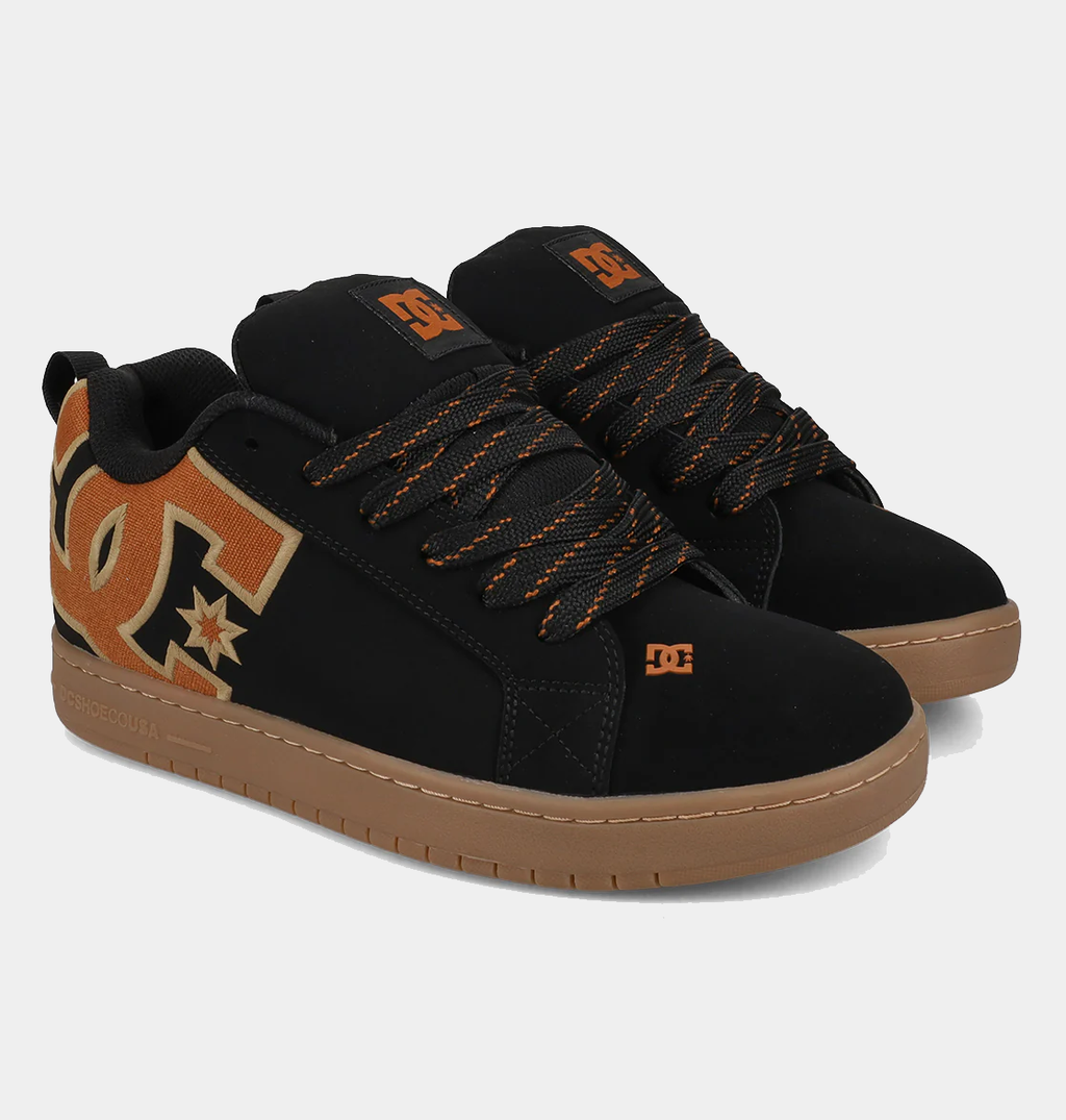 Black suede low-top sneakers with tan star graphic, orange lace details, gum sole
