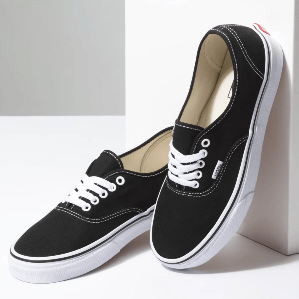 Black canvas low-top sneakers with white laces and white vulcanized rubber sole