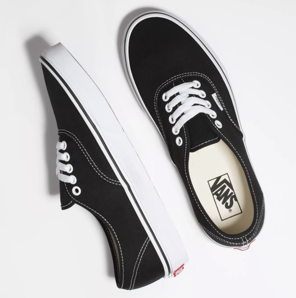 Black canvas sneakers with white laces and Vans logo patch on tongue