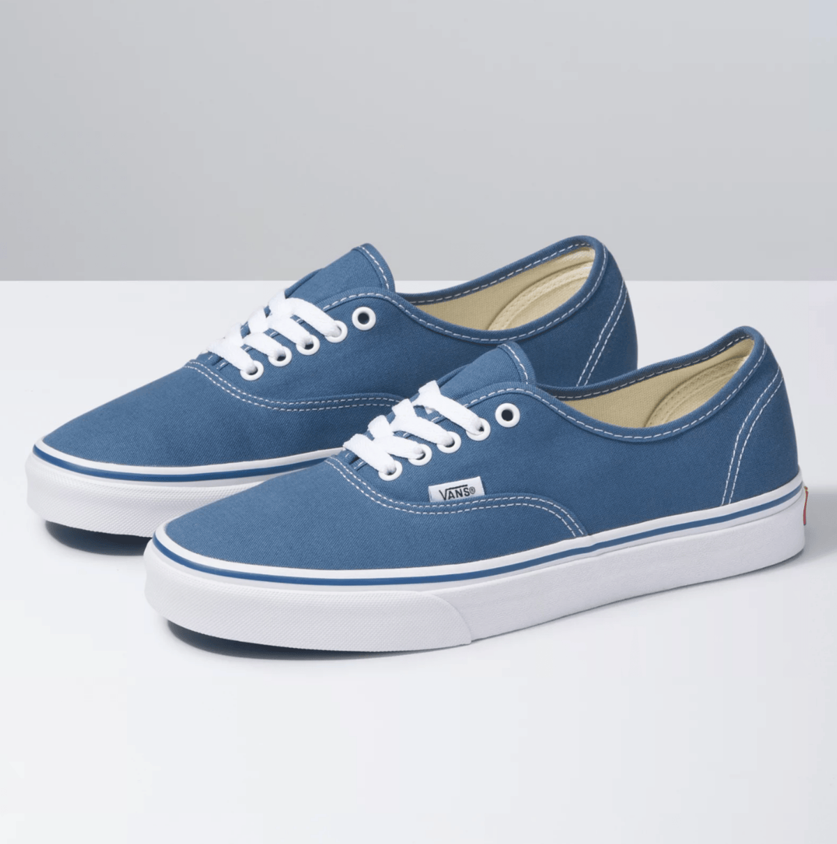 Pair of navy canvas low-top sneakers with white laces and blue trim