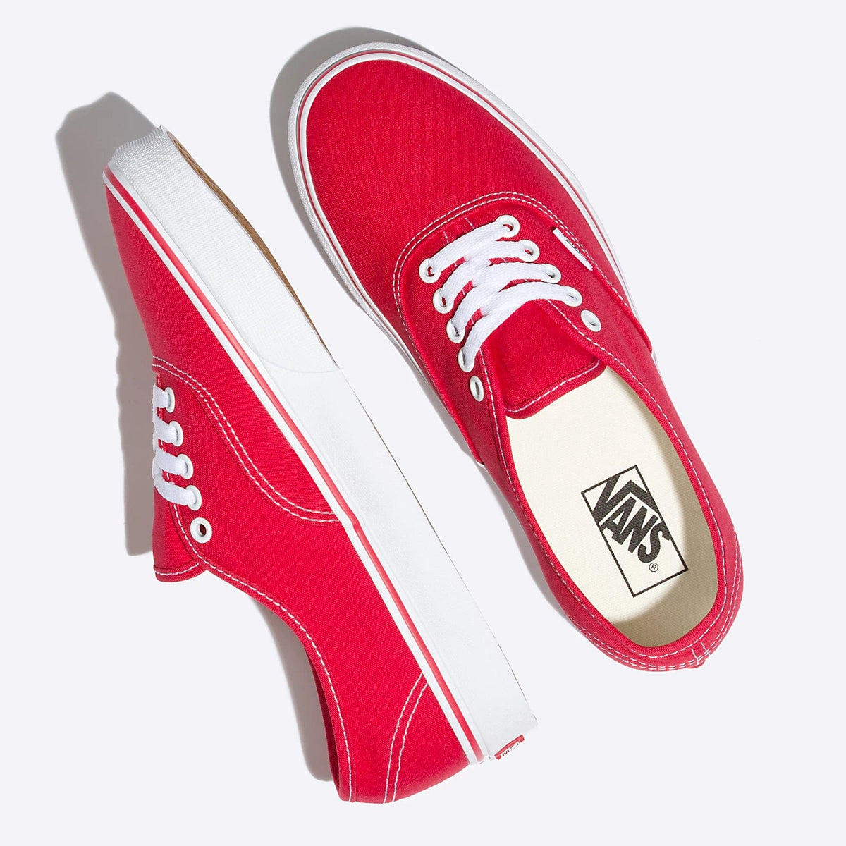 Red low-top sneakers from side view with Vans logo and white midsole stripe