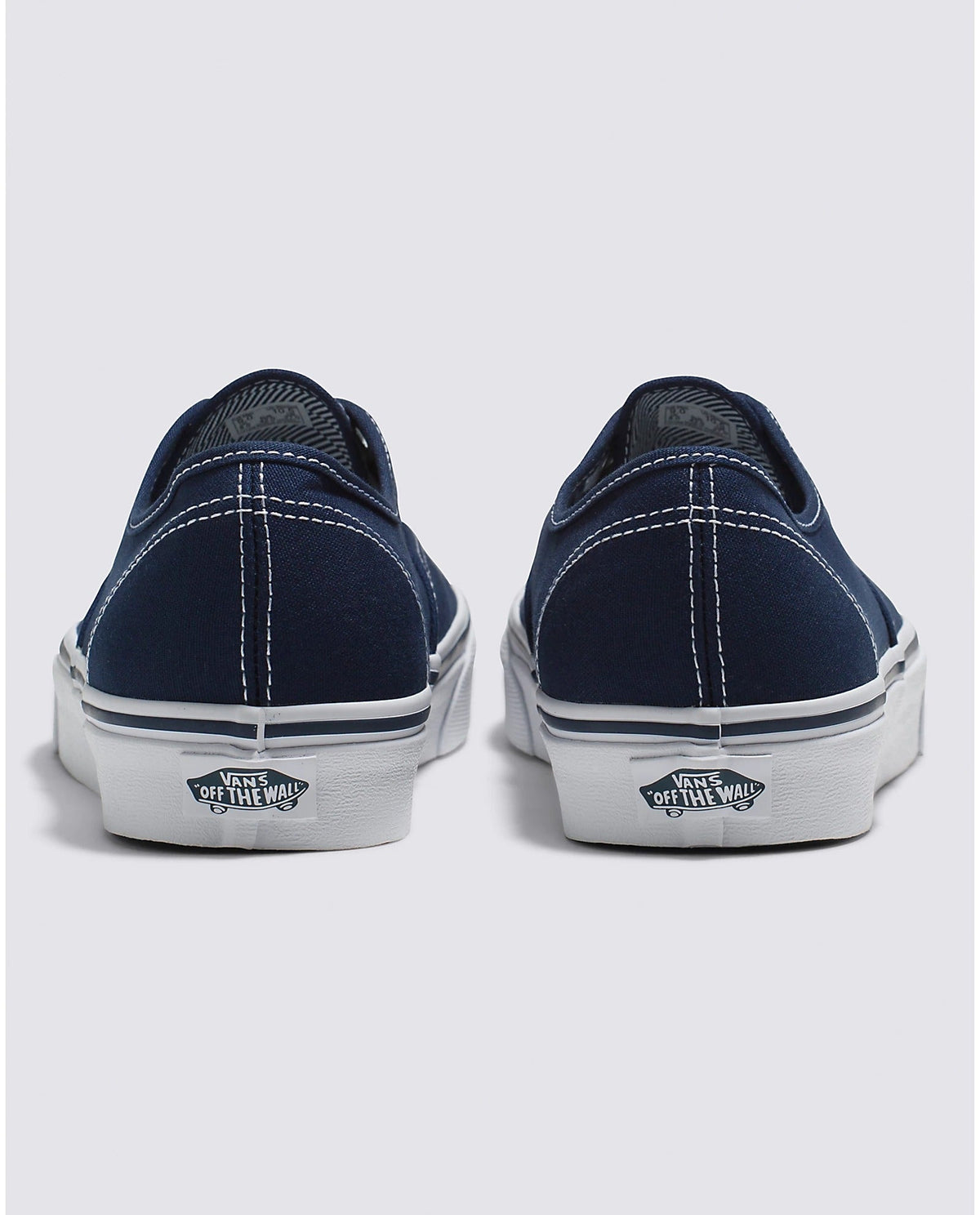 Back view of navy low-top sneakers with white midsoles and Vans branding on heel