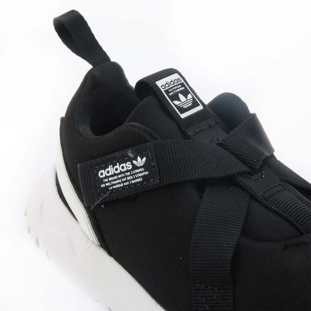 Black trainers close-up with adidas logo labels and hook-and-loop strap