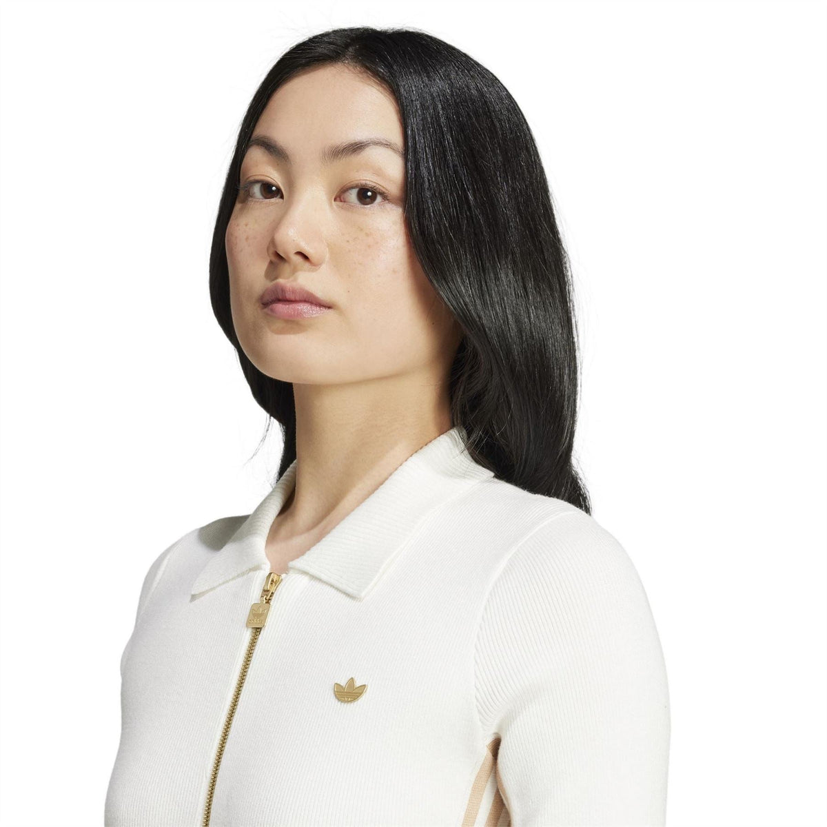 Off-white knit onesie close-up with quarter zip, ribbed knit texture, small chest logo