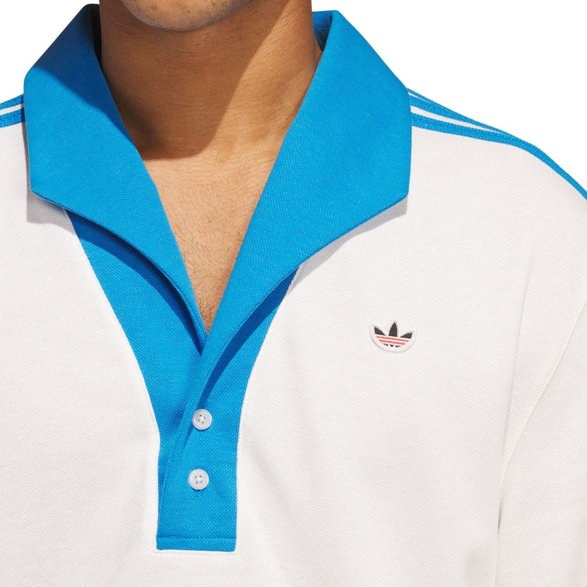 White polo shirt with blue collar and placket, featuring a small adidas trefoil chest logo.