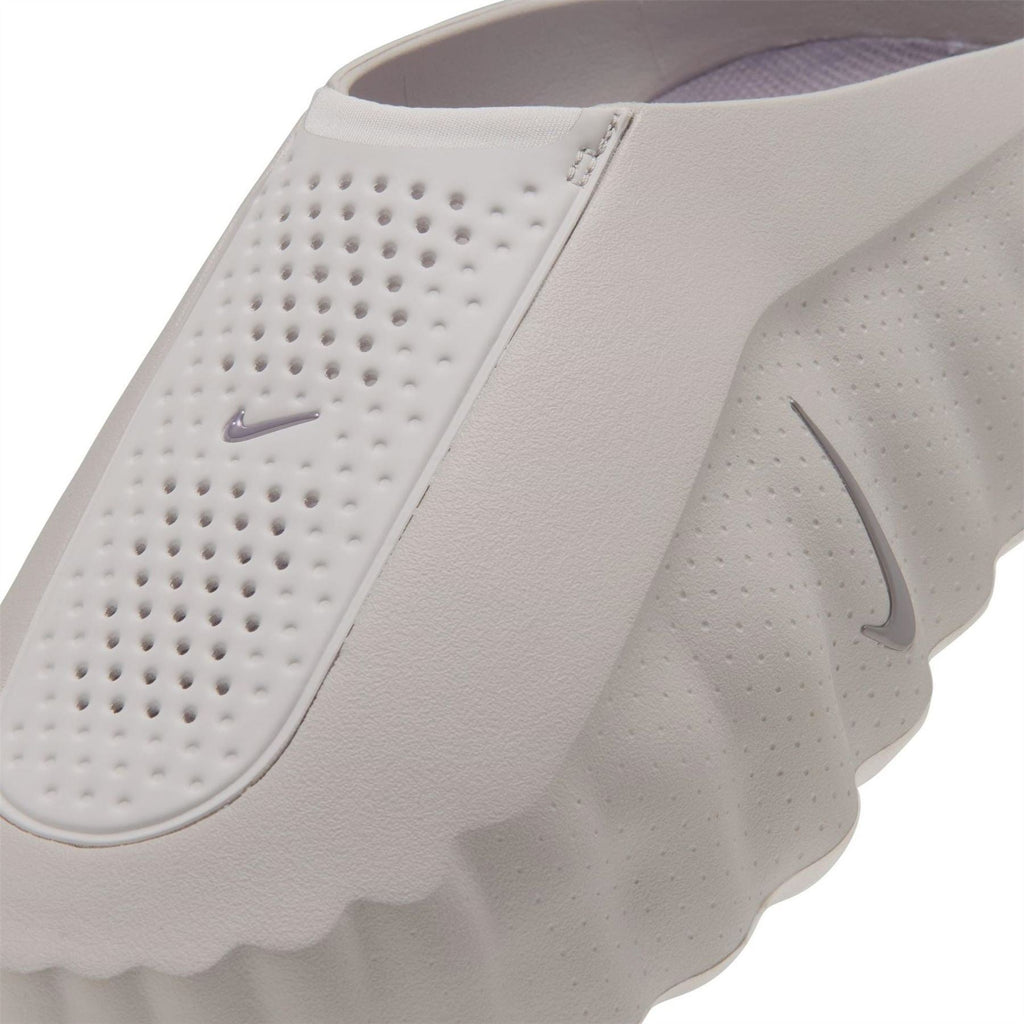 White Nike slide sandals close-up with perforated strap and Swoosh detail