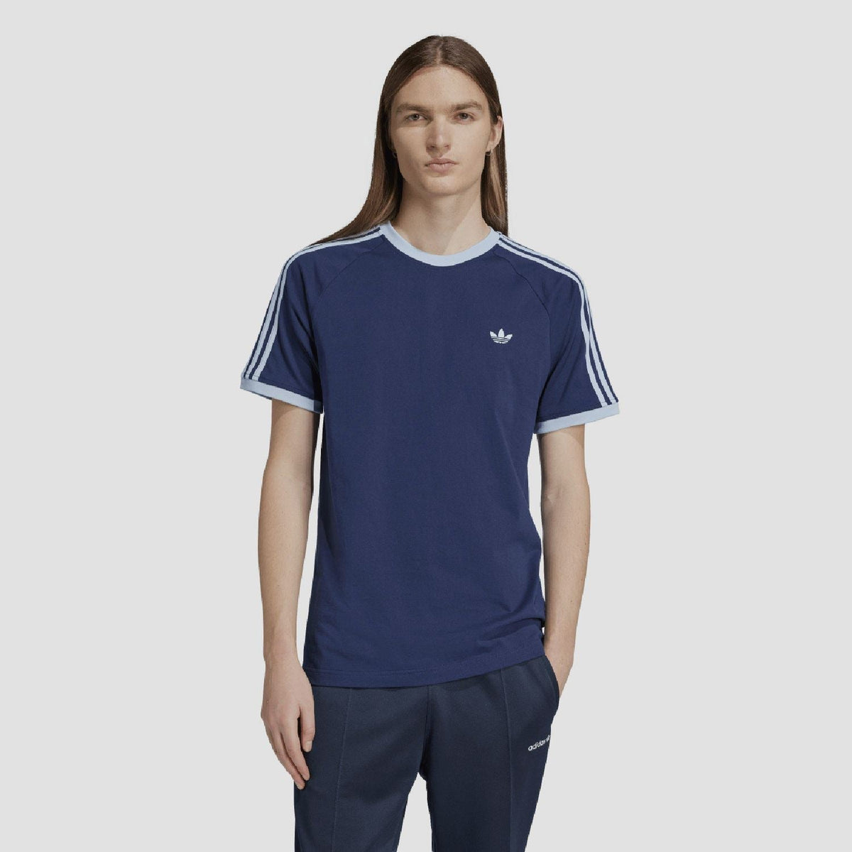Indigo adidas Originals T-shirt on model with white side stripes and small chest logo