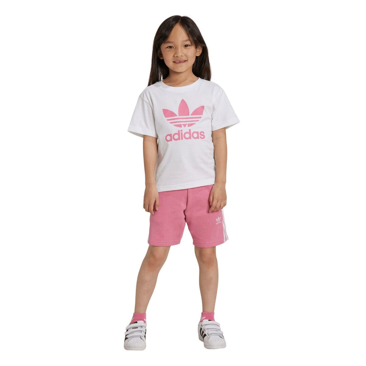 Girl wearing kids adidas set: white T-shirt with pink trefoil, pink shorts
