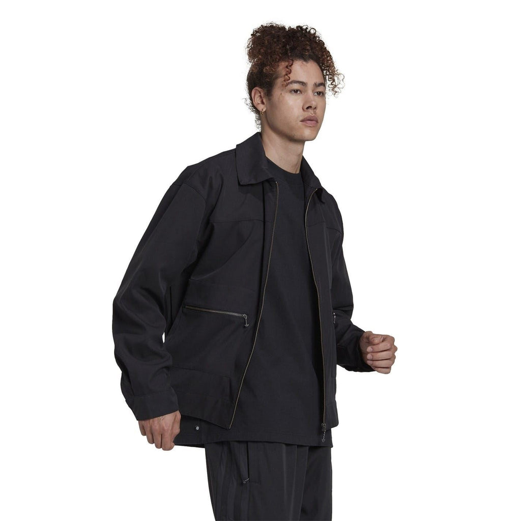 Black zip-up jacket with stand collar, chest pockets, and visible zipper placket