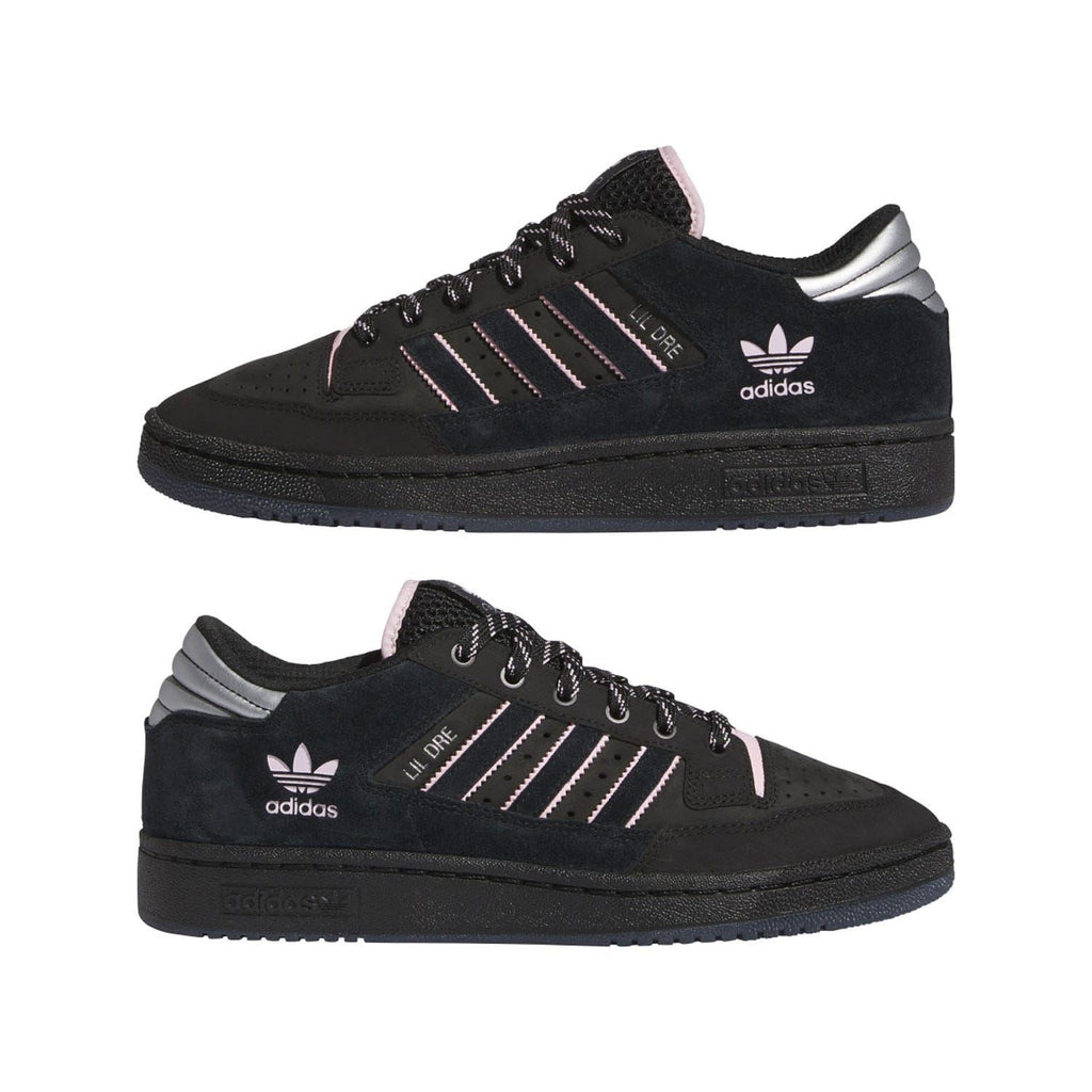 Pair of black low-top trainers with pink accents, stripe logo, and lace-up design