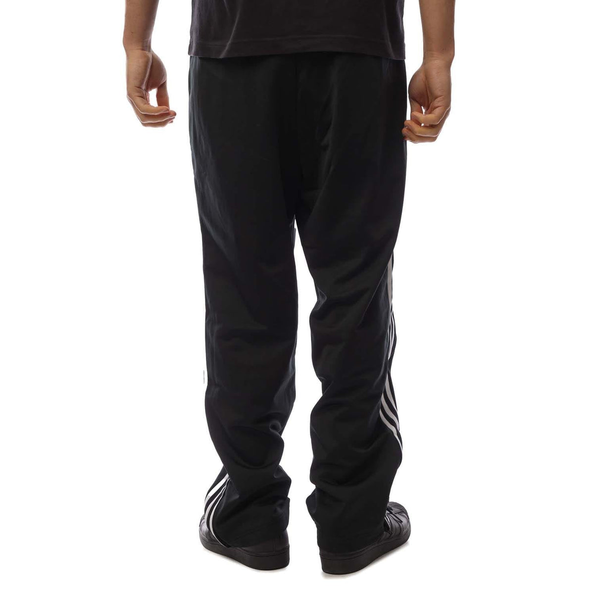 Black track pants showing full length straight leg with white stripe accents