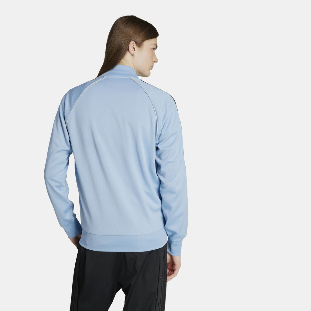 adidas Originals Adicolor Classic SST track jacket in navy with white stripes, front zipper, and ribbed cuffs and collar.