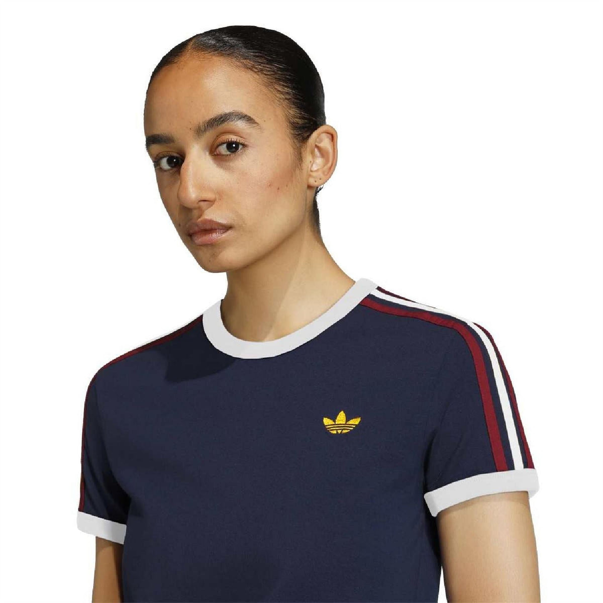 Navy crew-neck t-shirt with gold trefoil logo and red/white stripe detail at shoulders