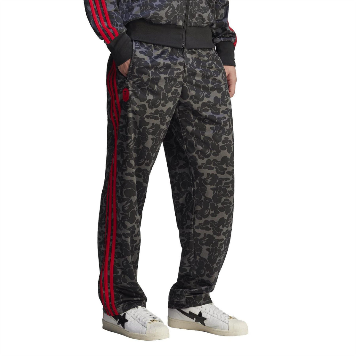 Black camo track pants with red side stripes and full-length tapered fit