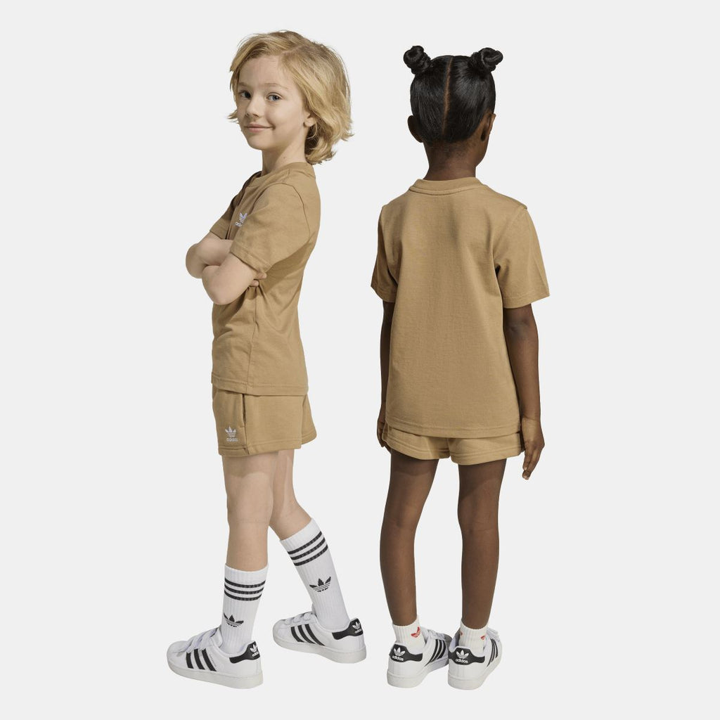 Tan adidas juniors T-shirt and shorts set on two models, side views; matching logos