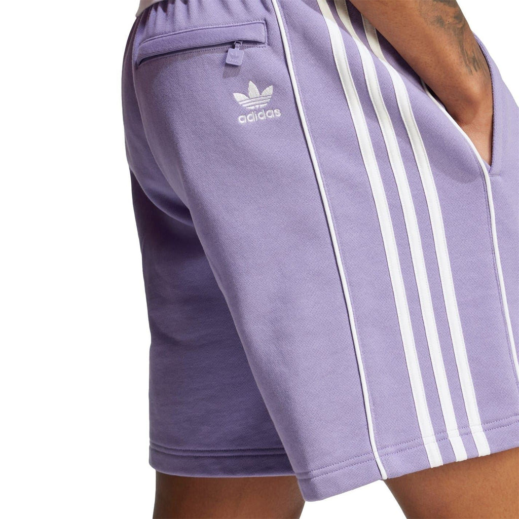 Lavender shorts with adidas logo and three white vertical stripe panels on side