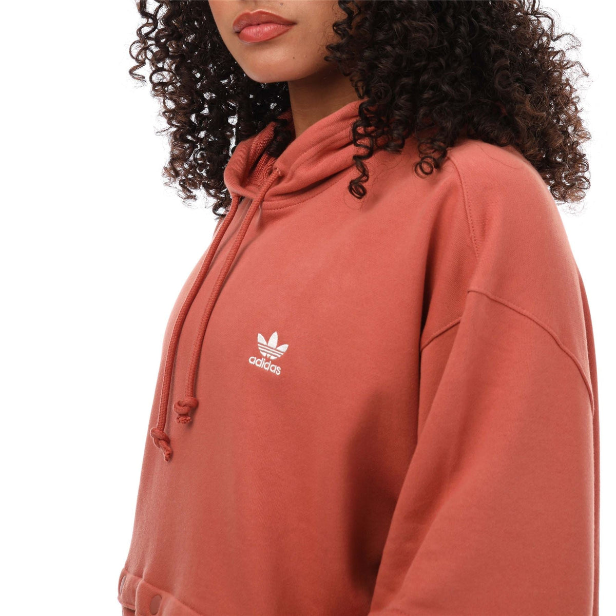 Pink hoodie close-up with trefoil logo and hood drawcords