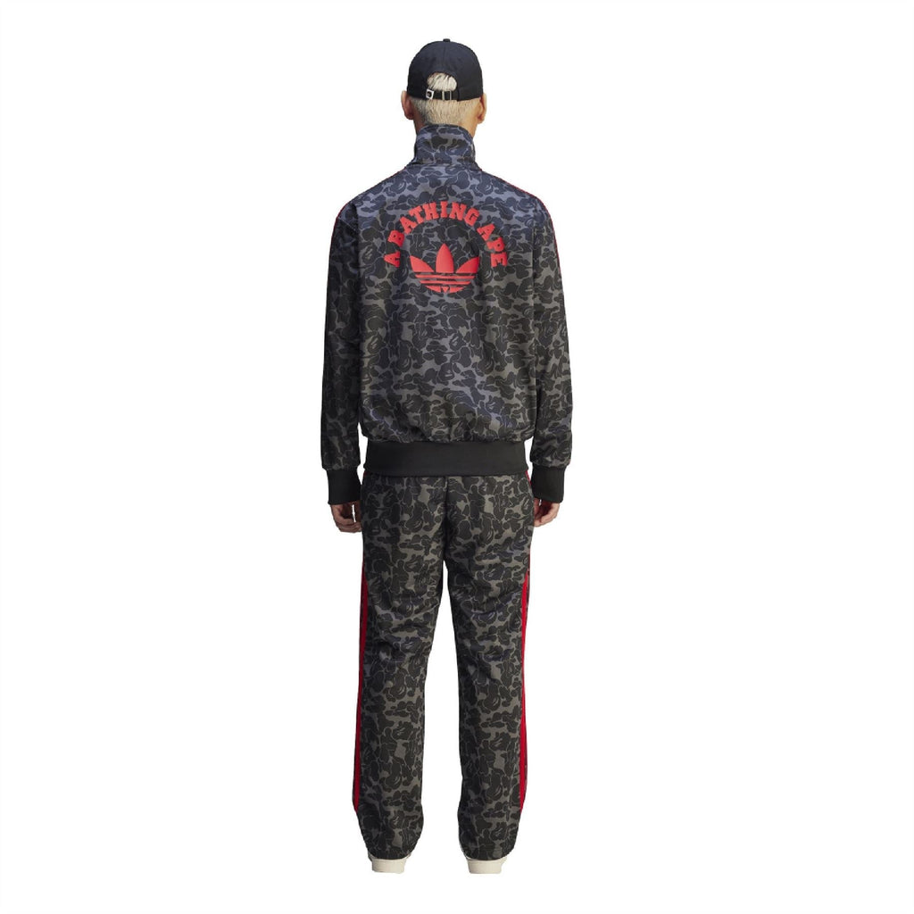 Back view camo trackpants with red side stripes and elastic waistband.