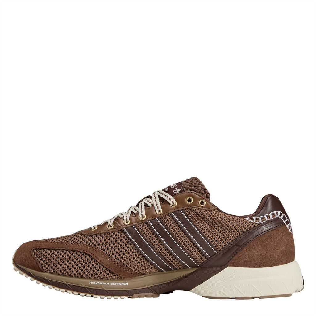 Brown and cream mesh sneakers with adidas-style stripes, lace-up front, side view.