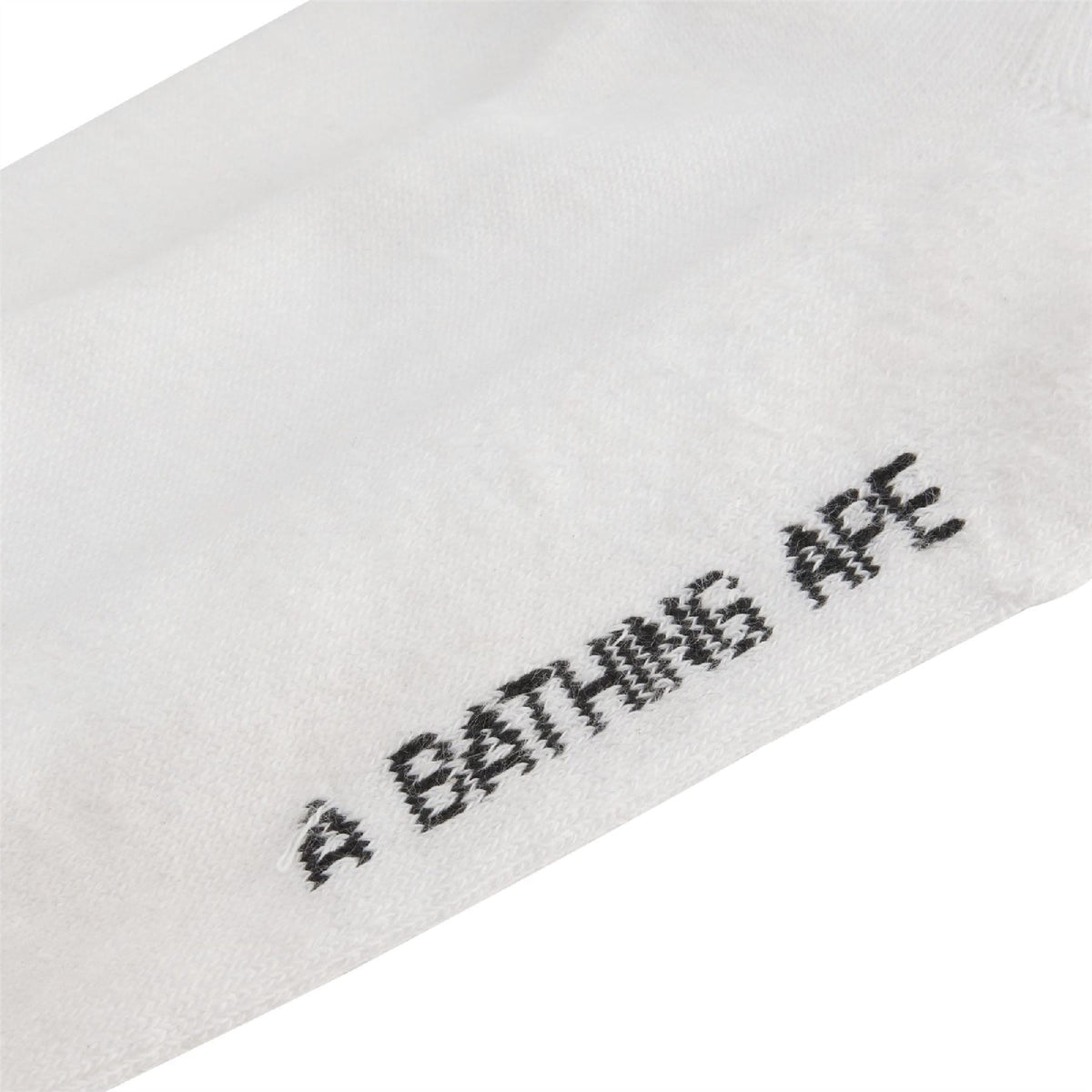 White crew sock with black 'EATIN APE' text