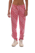 Pink track pants with repeating heart pattern, elastic waistband and ankle cuffs