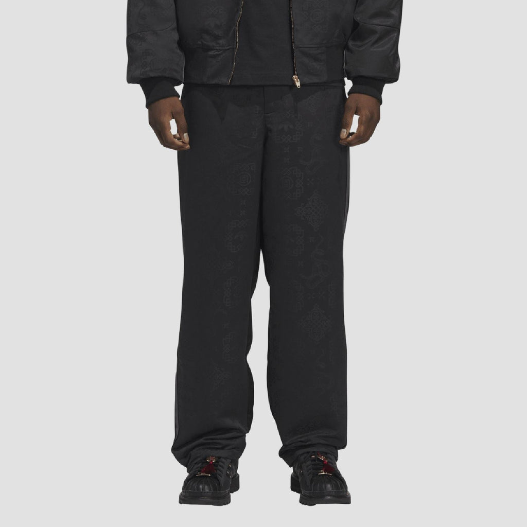 adidas Originals black tracksuit bottoms worn on model, ankle-length tapered cuffs