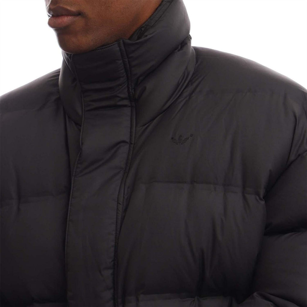 Black adidas Originals puffer jacket close-up with chest logo and full zip