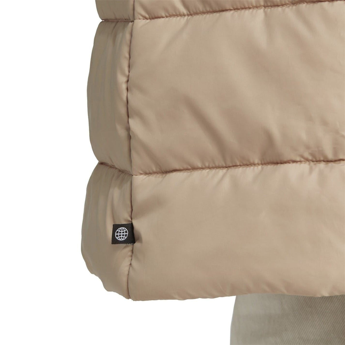 Beige puffer jacket sleeve panel with circular logo patch