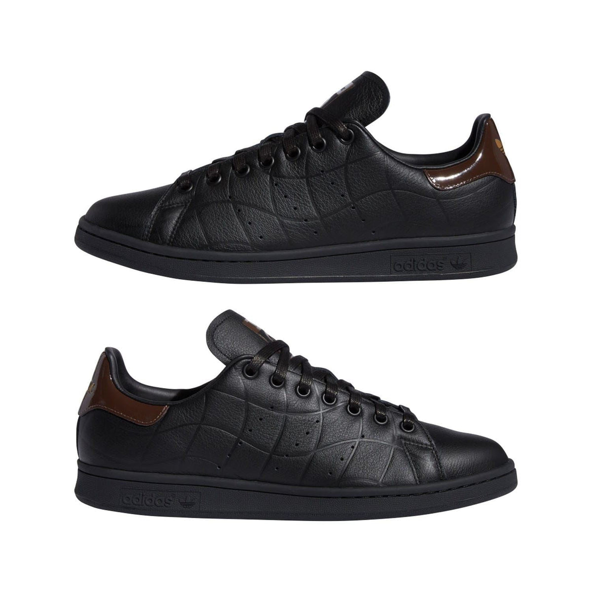 Pair of black leather lace-up trainers with brown heel accents and textured rubber soles