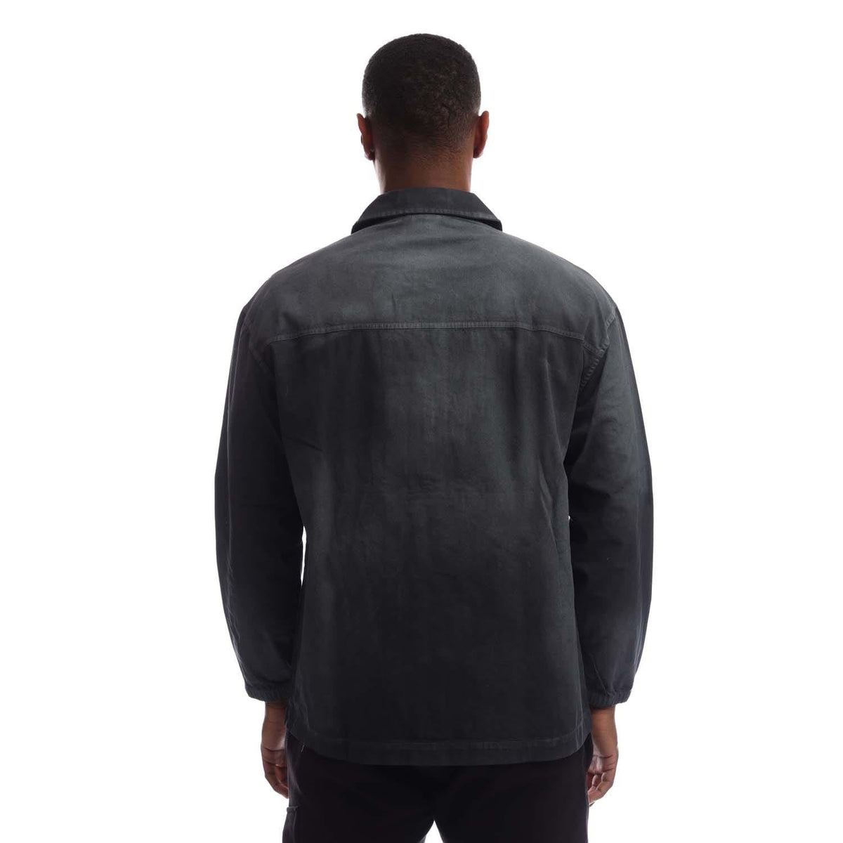 Back view of black coach overshirt with full-length sleeves and button closure