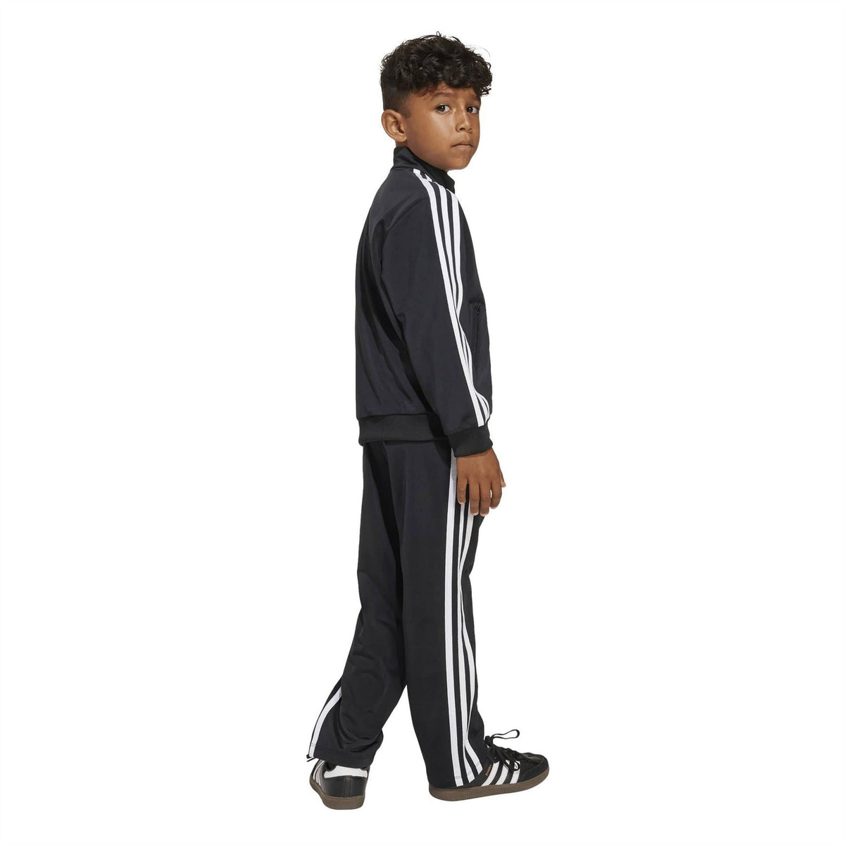 Kids adidas Firebird tracksuit, side view, black zip jacket and pants with white triple stripes