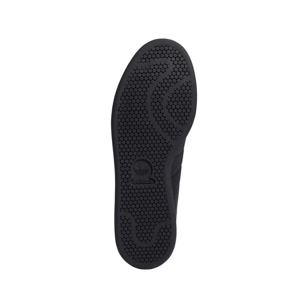 Black textured rubber outsole with circular grip pattern and logo