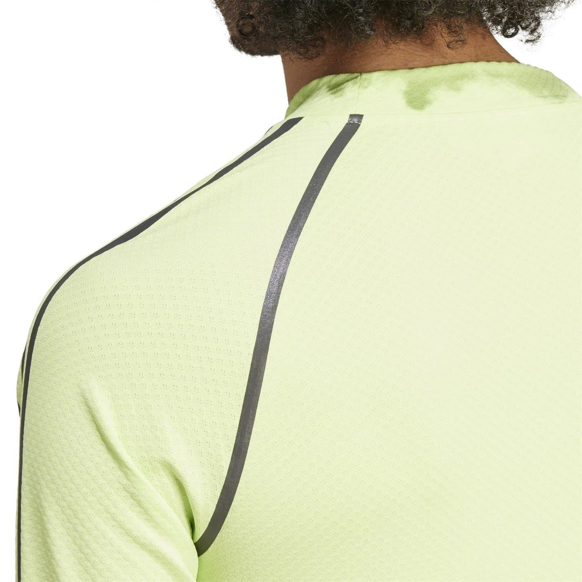 Close-up of lime green raglan t-shirt back with black vertical shoulder stripe